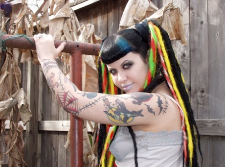 Goth girl Dana Dark pours wax over her natural tits in the backyard
