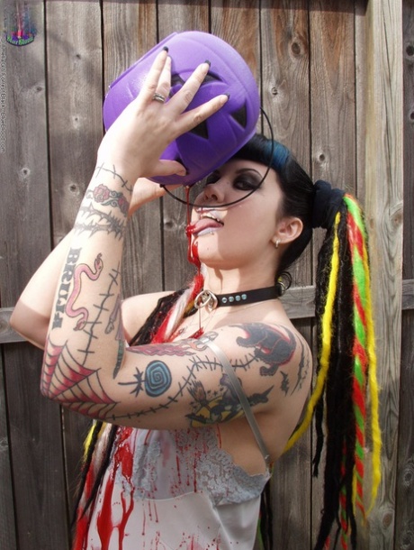 Goth girl Dana Dark pours wax over her natural tits in the backyard