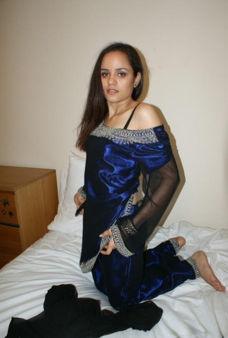 Indian solo girl cups her natural tits on a bed while in her underwear