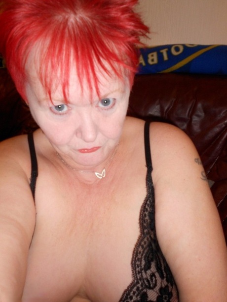 Mature redhead fatty Valgasmic Exposed exposes her bald pussy in fishnets