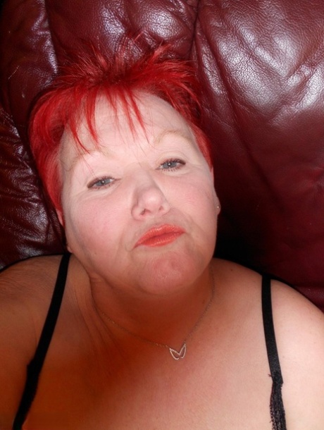 Mature redhead fatty Valgasmic Exposed exposes her bald pussy in fishnets