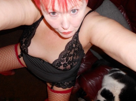 Mature redhead fatty Valgasmic Exposed exposes her bald pussy in fishnets