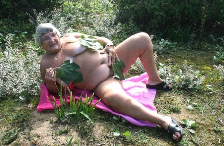 Fat British woman Grandma Libby gets naked on a towel upon scrubby ground