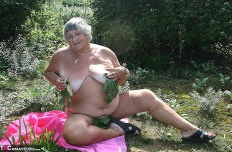 Fat British woman Grandma Libby gets naked on a towel upon scrubby ground
