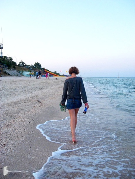 Amateur girl with red hair changes into a bikini before getting in the ocean