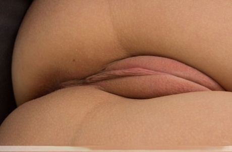 Naked teen Nika K slips a couple of fingers into her puffy pussy