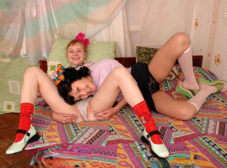 Young looking girls share a double ended dildo during interracial lesbian sex