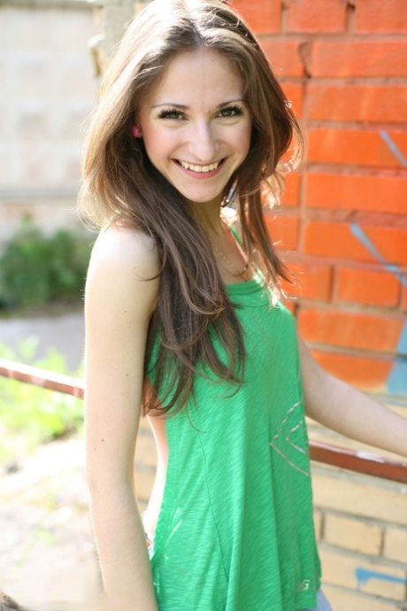 Petite teen Sveta exppses her tits and twat against a brick wall