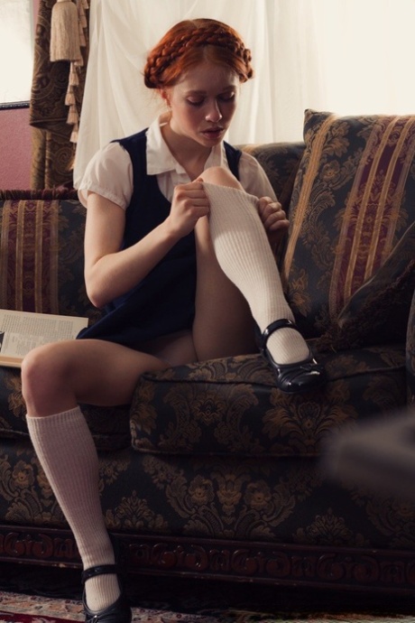 Young looking redhead Dolly Little gets naked in white socks and Mary Jane's