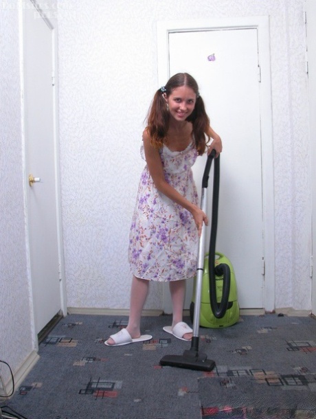 Young girl gets naked in white stockings while vacuuming a carpet