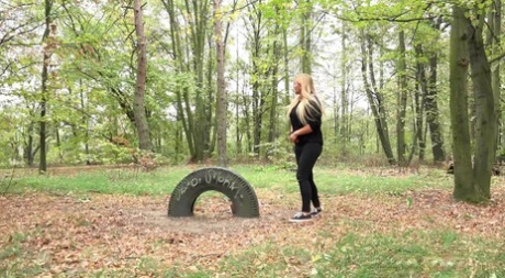 Blonde girl Jenna Lovely takes a pee on leaf strewn ground at a park