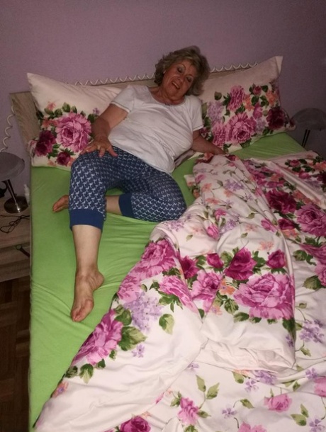 Horny older woman licks her nipple before dildoing her hairy pussy