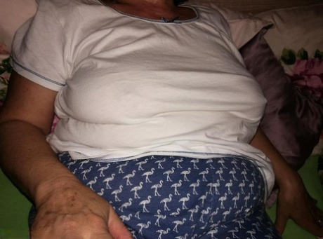 Horny older woman licks her nipple before dildoing her hairy pussy
