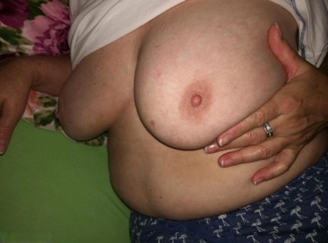 Horny older woman licks her nipple before dildoing her hairy pussy