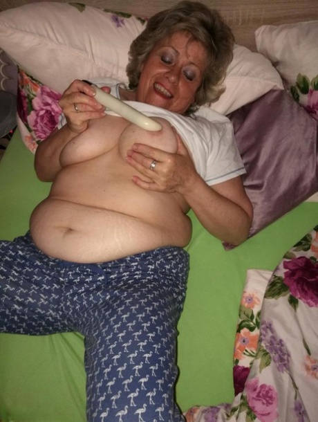 Horny older woman licks her nipple before dildoing her hairy pussy