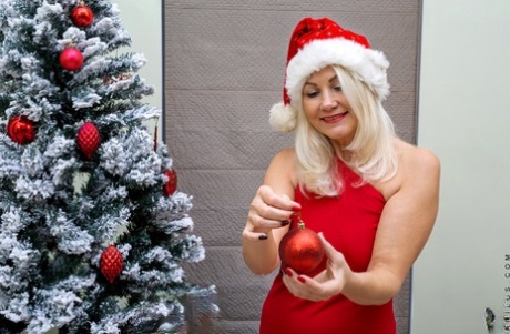 Mature blonde Sylvie sheds Xmas attire to make her nude debut by the tree