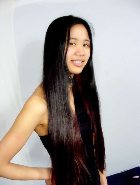 Young Chinese girl with tiny tits shows her shiny ass and naked pussy at once