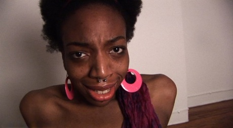 Naked black girl Sage sucks on a black dildo before pissing in a glass bowl