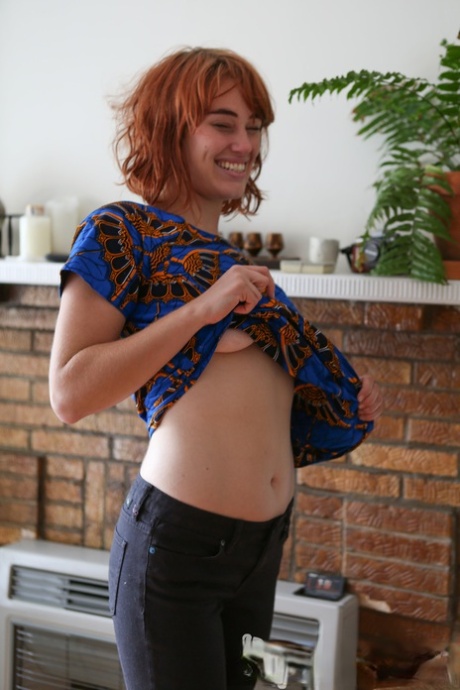Natural redhead Molly Broad pets her pussy after getting naked