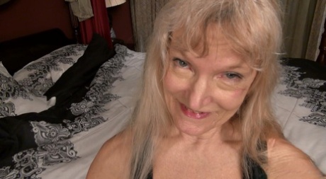 Blonde granny Cindy masturbates with a vibrator on her bed in the nude