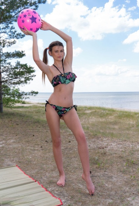 Tall teen Tora removes her bikini for nude poses in pigtails down by the water