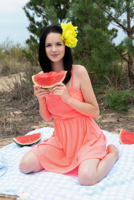 Sweet teen Stacy eats a watermelon while getting naked outdoors on a blanket