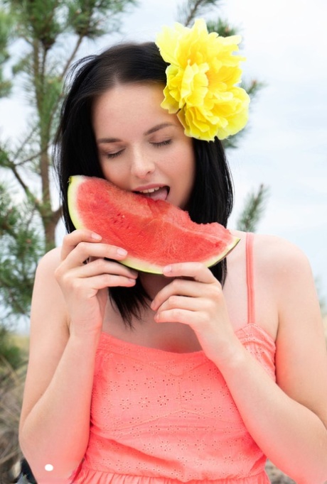 Sweet teen Stacy eats a watermelon while getting naked outdoors on a blanket