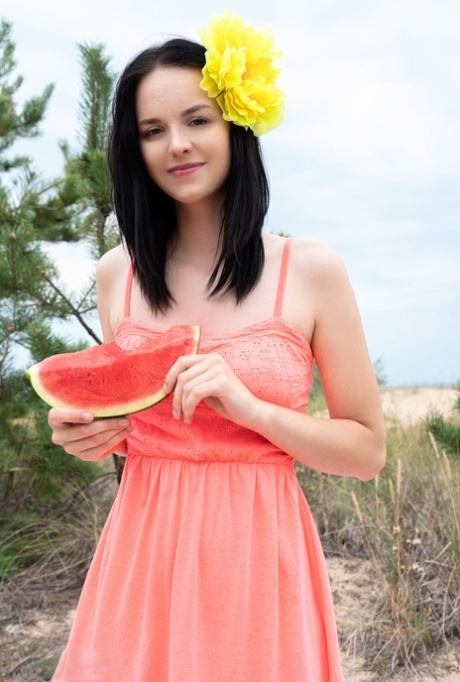 Sweet teen Stacy eats a watermelon while getting naked outdoors on a blanket