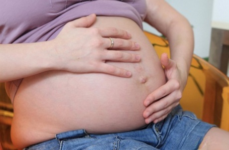 Pregnant girl spills milk over her swollen breasts and huge belly