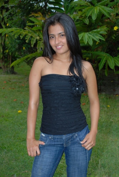 Hot black haired Jeniffer does a striptease on the lawn to finger her pussy