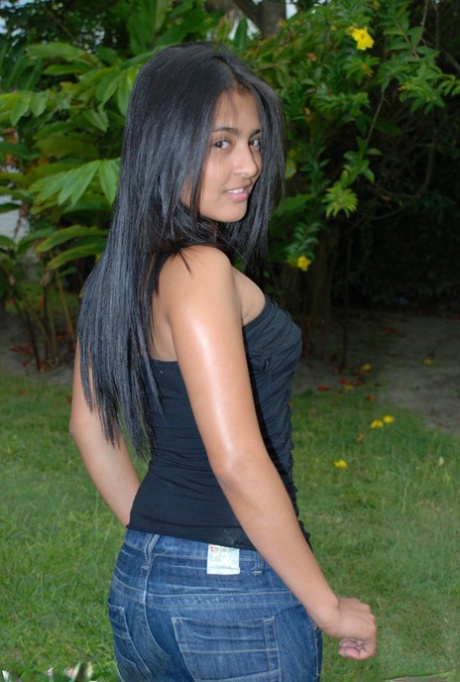 Hot black haired Jeniffer does a striptease on the lawn to finger her pussy