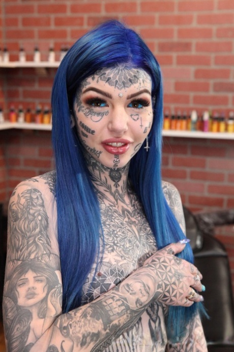 Heavily tattooed girl Amber Luke poses naked in a tattoo shop