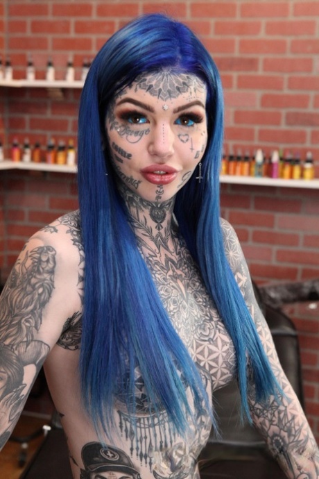 Heavily tattooed girl Amber Luke poses naked in a tattoo shop