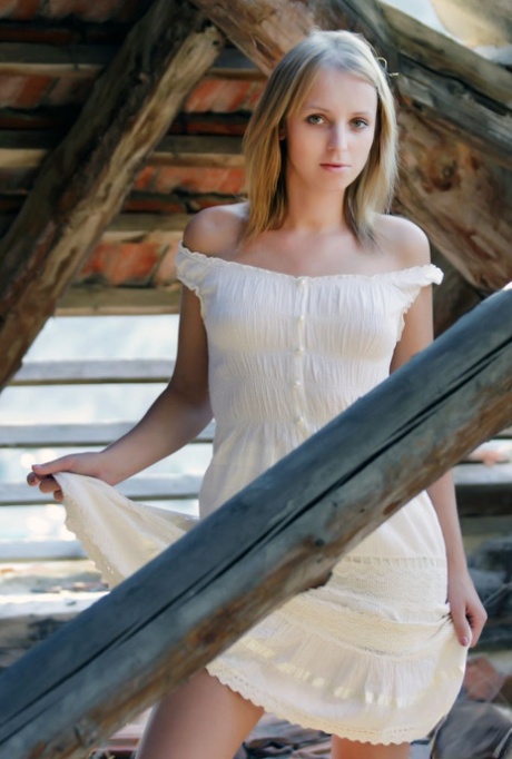 Young blonde Ilona D gets naked in a rustic setting with her boots on