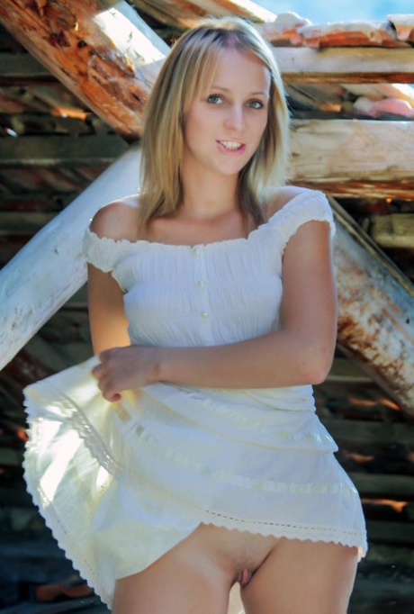 Young blonde Ilona D gets naked in a rustic setting with her boots on
