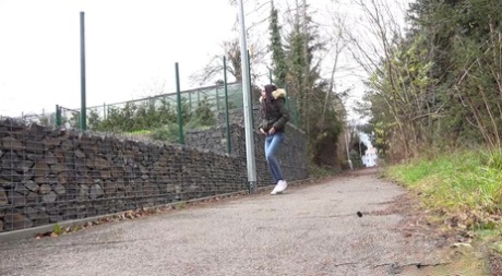 Brunette girl Mistika gets caught with her pants down while peeing on a road