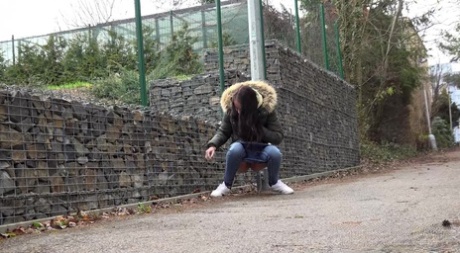 Brunette girl Mistika gets caught with her pants down while peeing on a road