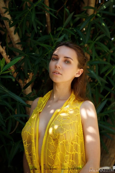 Teen model with full breasts shows her trimmed muff on a backyard patio