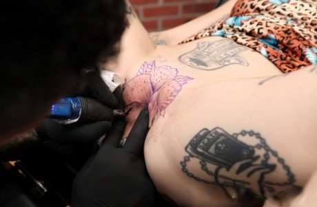 Inked girl River Dawn gets a pussy tattoo before sucking the cum from a cock