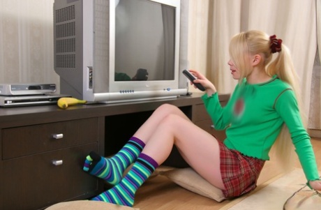 Cute blonde teen Olya N peels a banana while getting naked in striped socks