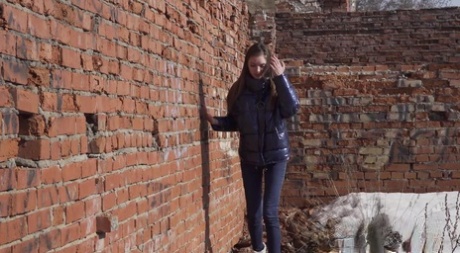 Vika Lita pulls down her pants to pee at what's left of a brick building