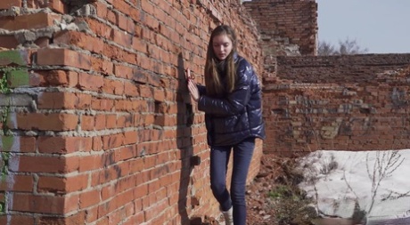 Vika Lita pulls down her pants to pee at what's left of a brick building