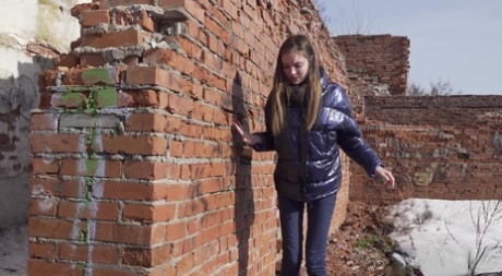 Vika Lita pulls down her pants to pee at what's left of a brick building