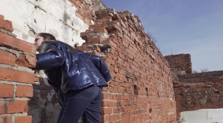 Vika Lita pulls down her pants to pee at what's left of a brick building