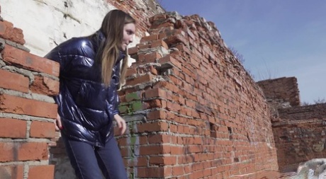 Vika Lita pulls down her pants to pee at what's left of a brick building