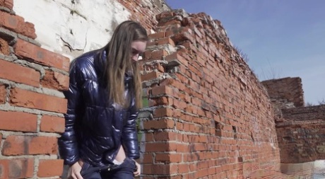 Vika Lita pulls down her pants to pee at what's left of a brick building