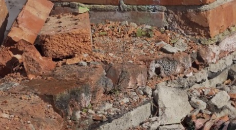 Vika Lita pulls down her pants to pee at what's left of a brick building