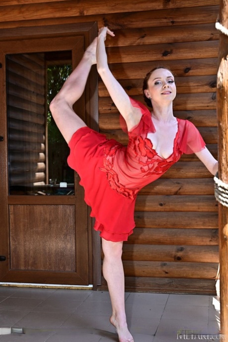 Flexible girl Stacy Redi gets completely naked while out on a balcony