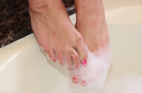Mature fatty Melody gets in a bubble bath while fully clothed