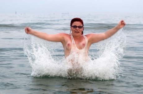 Mature UK redhead Mollie Foxxx exposes her tits and pussy while in the ocean